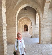 Photo of Fozio Bora standing within medieval archways